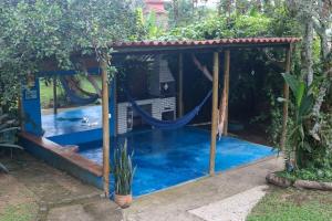 a pool with a hammock in a gazebo at Sobrado da Casa Azul - Penedo in Itatiaia