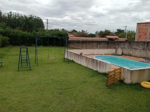 a swimming pool with a ladder and a swing at Cantinho da Paz in Capela do Alto