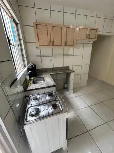 a small kitchen with a stove and a sink at Alojamento Obracamp in Campinas