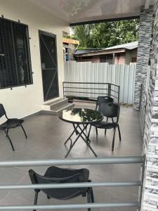 a patio with a table and chairs and a bench at Alis786 Apartment in Lautoka