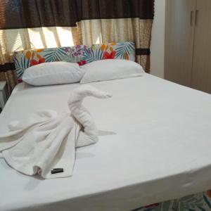 a white bed with a towel on top of it at Alis786 Apartment in Lautoka