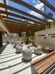マセイオにあるStudio Design 3 Apt 802 -Mandi Hospitalidadeの木製の天井が特徴のパティオ(白い椅子、テーブル付)