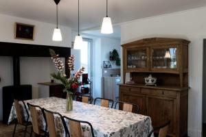 a dining room with a table with chairs and a cabinet at Gîte de France Belleviste 3 épis - Gîte de France 10 personnes MAE-1521 in Queyssac-les-Vignes