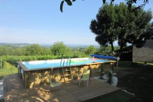 a swimming pool with two chairs and a table at Gîte de France Belleviste 3 épis - Gîte de France 10 personnes MAE-1521 in Queyssac-les-Vignes