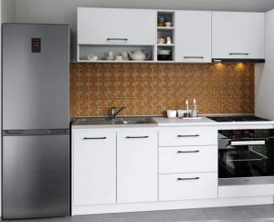 a kitchen with white cabinets and a stainless steel refrigerator at George Apartament Central cu gradina proprie in Sinaia