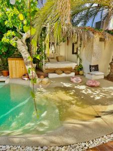 a swimming pool with a palm tree and a house at Casa Klod Ibiza in Ibiza Town