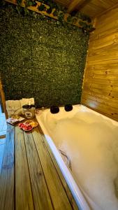 a bath tub in a room with a wooden floor at Pousada dos Canyons - chalé 01 in Praia Grande