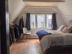 a bedroom with a bed and a window and a chair at New V in Amsterdam