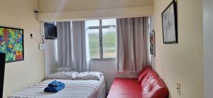 ein kleines Zimmer mit einem Bett und einem Fenster in der Unterkunft Edifício Urca in Angra dos Reis