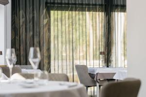 a dining room with white tables and chairs and a window at 't pure genot in Dilsen-Stokkem