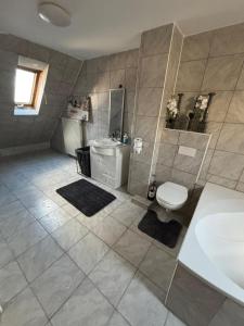 a bathroom with a tub and a toilet and a sink at Benk 24H Apartment Nr 3 Perfekt für bis zu 6 Personen in Hofheim am Taunus