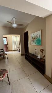 a living room with a couch and a ceiling fan at Pousada Recreio Casa Grande in Cascavel