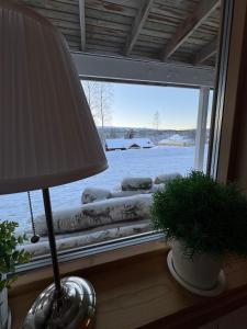 una lámpara junto a una ventana con un patio cubierto de nieve en Hyllan, en Sälen