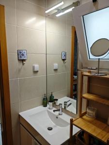 a bathroom with a sink and a mirror at The Sunny Cottage by Freetimealgarve in Faro