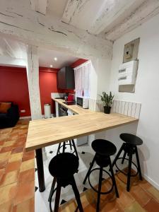 una cucina con tavolo in legno e 4 sgabelli di l'Hibiscus a Rouen