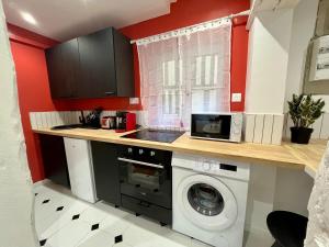 una cucina con lavatrice e microonde di l'Hibiscus a Rouen Altre 3 foto