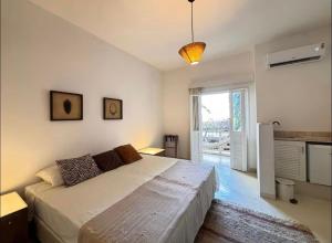 a bedroom with a large bed and a large window at Apartamento Mãe África Centro Morro de São Paulo in Morro de São Paulo