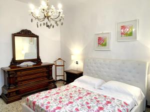 ein Schlafzimmer mit einem Bett mit Spiegel und einer Kommode in der Unterkunft Appartamenti Tina Paolini 2 con terrazzo in Castiglione della Pescaia