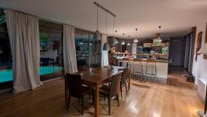 Un comedor y una cocina con mesa y sillas de madera. en Wooden house with indoor pool, en Saint-Médard-dʼAunis