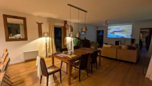 Una sala de estar con una mesa de comedor y un sofá. en Wooden house with indoor pool, en Saint-Médard-dʼAunis