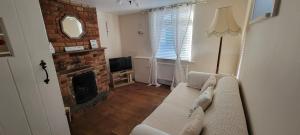 a living room with a couch and a fireplace at Bee Cottage in Sandown