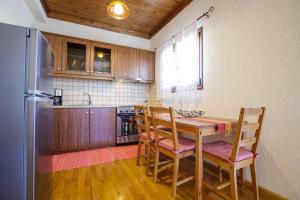 a kitchen with a table and chairs and a refrigerator at Holiday house Elliniko Arcadia in Elliniko