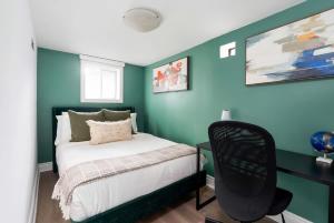 una camera da letto con pareti verdi e un letto con una sedia di Private 2 Storey Home with 3BR-2BA by Queen West a Toronto