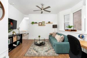 un soggiorno con divano blu e ventilatore a soffitto di Private 2 Storey Home with 3BR-2BA by Queen West a Toronto