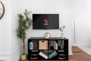 una TV su un muro sopra una mensola nera di Private 2 Storey Home with 3BR-2BA by Queen West a Toronto