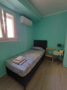 a small bedroom with a bed and a chair at Athinas Residence in Myrina