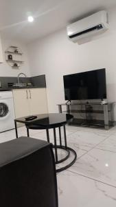 a living room with a table and a flat screen tv at Cozy and well located apartment in Tremblay En France
