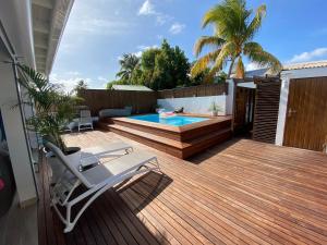 drewniany taras z basenem i krzesłem w obiekcie Villa Bleue des Sables hypercentre marina plage w mieście Saint-François