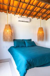 a bedroom with a blue bed with two hanging lights at Kitesurfing Paradise, Beautiful Beach House in Taíba +58 photos