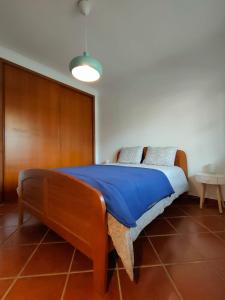a bedroom with a bed with a blue blanket at Ericeira Beach House in Ericeira +29 photos