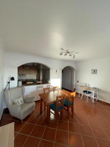 a living room with a table and chairs and a kitchen at Ericeira Beach House in Ericeira
