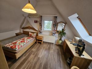 a small attic bedroom with a bed and a desk at Landhotel "Zum ersten Siedler" in Brieselang +90 photos