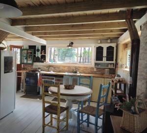 a kitchen with a table and chairs in a kitchen at Hermosa Cabaña a 400mt del mar in Rocha