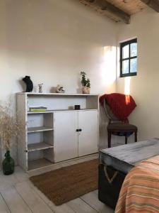 a bedroom with a white cabinet and a chair at Hermosa Cabaña a 400mt del mar in Rocha