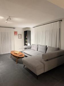 a living room with a couch and a coffee table at Alpinelounge -modern - spacious in Waltenhofen
