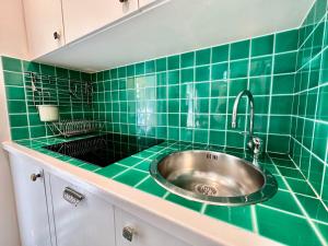 a green tiled kitchen with a stainless steel sink at Villa Angelina Holiday Homes I Casa UG I Antica Villa I Giardino I 4 ospiti I Mare 5 min I Parcheggio privato in Vallecrosia +23 photos