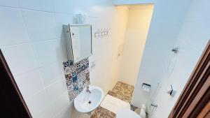 a bathroom with a toilet and a mirror at Casa Bem-te-vi - Passarim Hospedagem in Cumuruxatiba