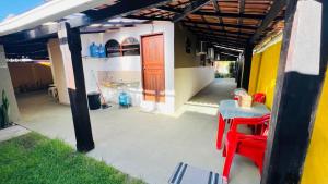 a patio with a table and chairs under a pergola at Casa Bem-te-vi - Passarim Hospedagem in Cumuruxatiba +6 photos
