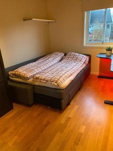a bed in a room with a wooden floor at Large single-family home for rent World Cup 2025 in Trondheim