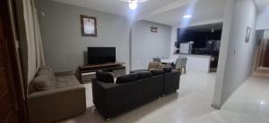 a living room with couches and a tv and a kitchen at vitor hugo in Corumbá