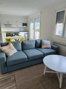 Una sala de estar con un sofá azul y una mesa. en Escolar, en Cedeira