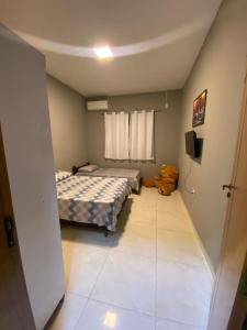 a small bedroom with two beds and a window at vitor hugo in Corumbá