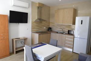 a kitchen with a white table and a white refrigerator at Llano 71 -B- in Archidona