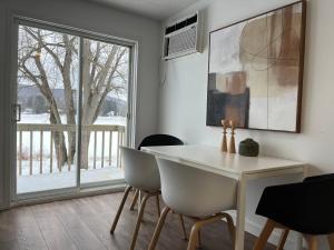a dining room with a table and chairs and a window at Hôtel Matha in Saint-Jean-de-Matha