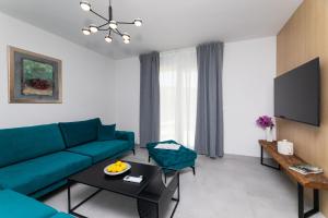 a living room with a blue couch and a table at Apartment Bracholet in Supetar