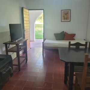 ein Zimmer mit einem Bett, einem Tisch und einem Fernseher in der Unterkunft Don Juan M Cabañas in Villa Las Rosas